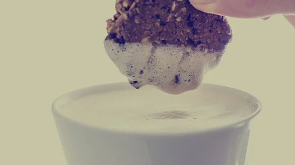Személy dunking egy keksz, egy csésze kávé — Stock Fotó