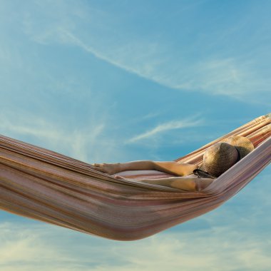 Woman relaxing in a hammock clipart