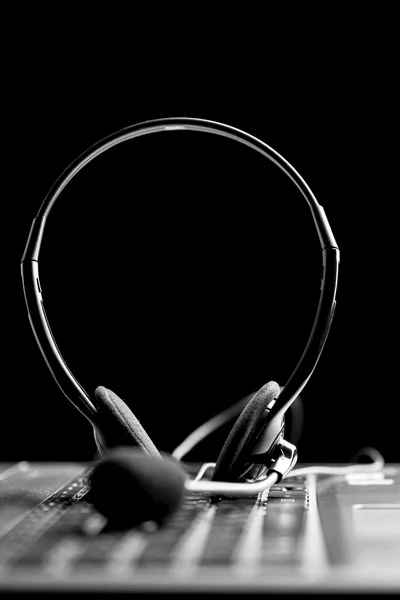 Headset on a laptop computer keyboard — Stock Photo, Image