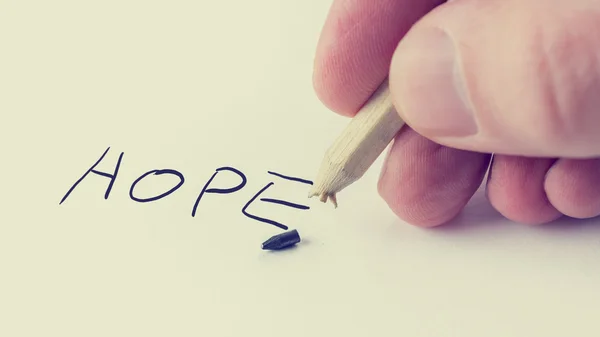 Man writing the word Hope on notepaper — Stock Photo, Image