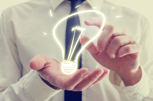 Businessman with creative light bulb icon — Stock Photo, Image