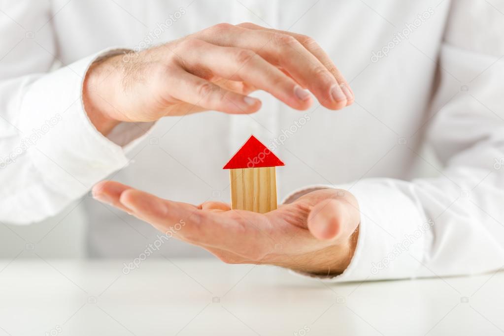 Man protecting a model house in his hands