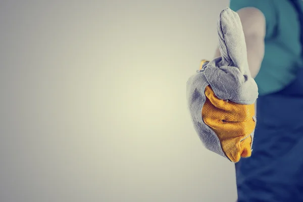 Hand in een beschermende handschoen duimen omhoog teken maken — Stockfoto