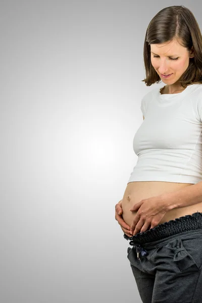 Zwangere vrouw rustplaats van haar buik in haar handen — Stockfoto