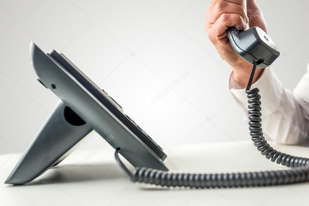 Telephone with the receiver held by a male hand