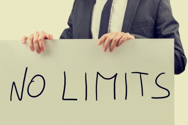 Businessman holding up a sign saying - No Limits clipart