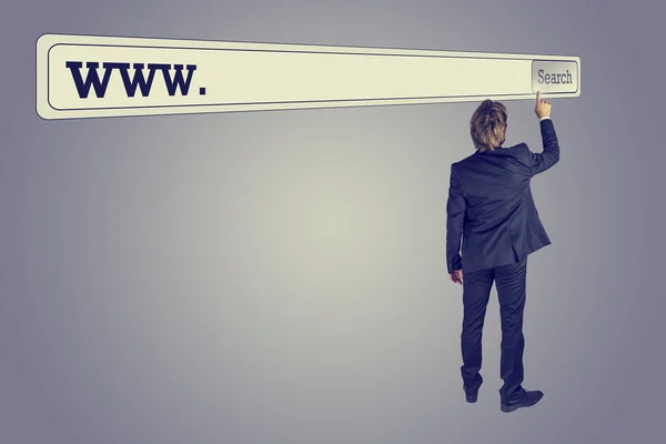 Hombre tocando el botón de una enorme barra de búsqueda — Foto de Stock