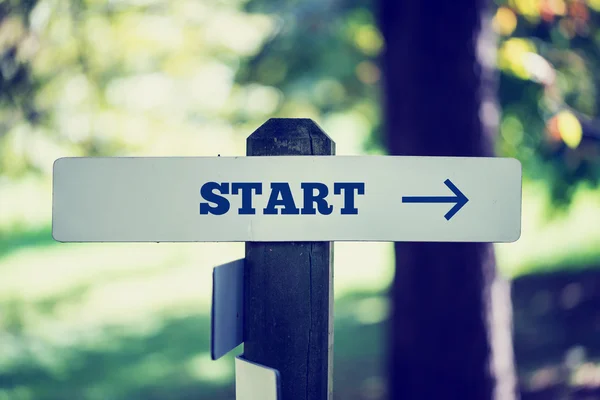 Oldr rustic signpost with the word Start