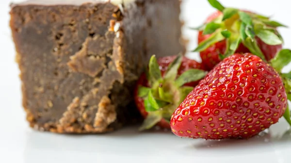 Fecho de morangos frescos ao lado de um bolo de chocolate — Fotografia de Stock