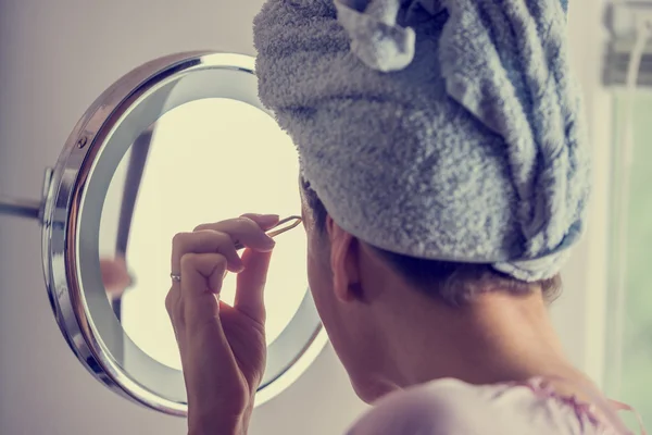 Woman plucking her eyebrows — Stock Photo, Image
