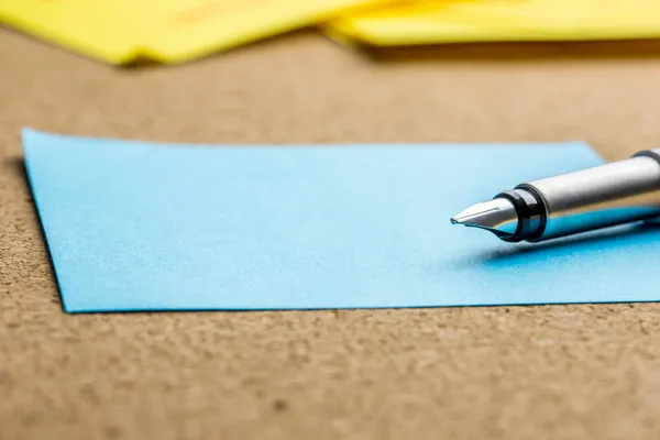 Pluma estilográfica sobre una hoja de papel azul — Foto de Stock