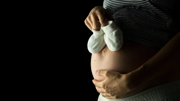 Embarazada mujer holding bebé botines — Foto de Stock