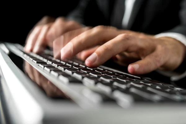 Mani di un uomo che digita velocemente su una tastiera del computer — Foto Stock