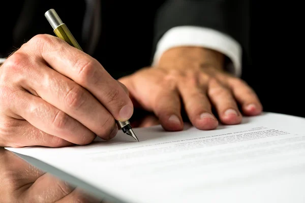 Man signing a typed document Royalty Free Stock Photos