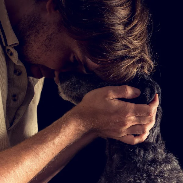 Homem amoroso abraçando seu cão terrier — Fotografia de Stock