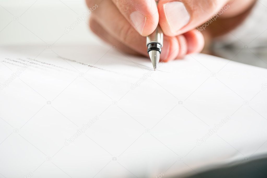 Man writing on a document with a fountain pen