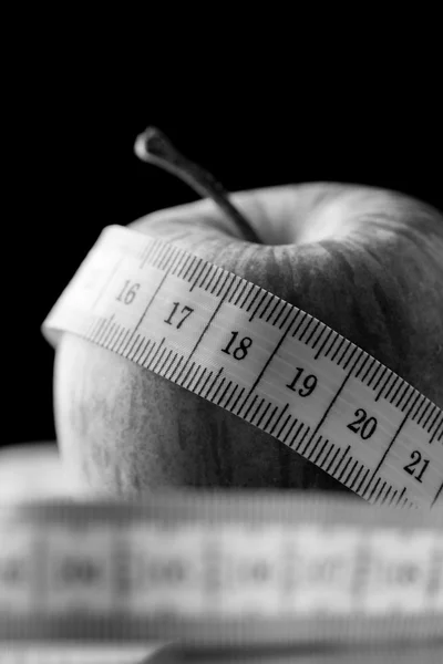 Fita métrica enrolada em torno de uma maçã — Fotografia de Stock