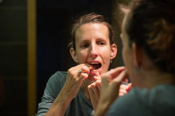 Young Woman Flossing Her Teeth Looking Bathroom Mirror — Stock Photo, Image