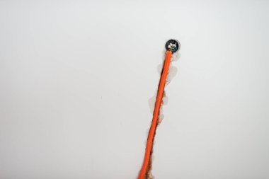 Elektrik kabloları için turuncu kıvrımlı tüp, bir duvara konsept yapı ve kurulum görüntüsü yerleştiriliyor..