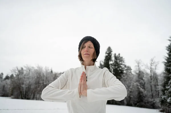 若いです女性瞑想と彼女の手のひら参加フロント彼女の胸立って外に雪の冬の自然 — ストック写真