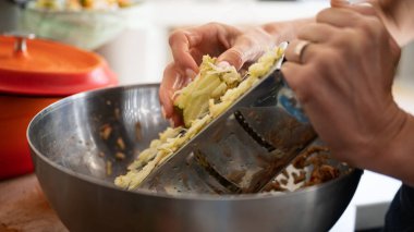 Yakından bakınca, elmayı rendeleyen bir kadın çelikle turta ya da tatlı hazırlıyor..