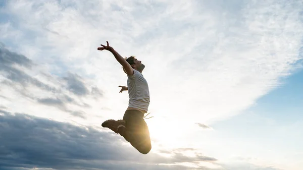 Heyecanlı Genç Adam Gündelik Giysiler Içinde Havada Zıplıyor Kollarını Gökyüzüne — Stok fotoğraf