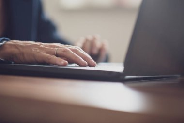 Low angle view of female hand using laptop computer working or searching the internet.