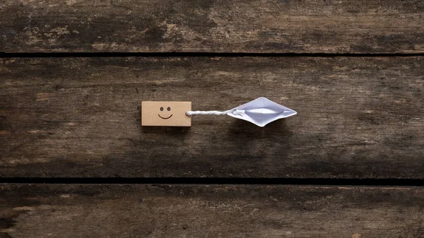 Top View Origami Paper Boat Pulling Wooden Peg Smiling Face — Zdjęcie stockowe