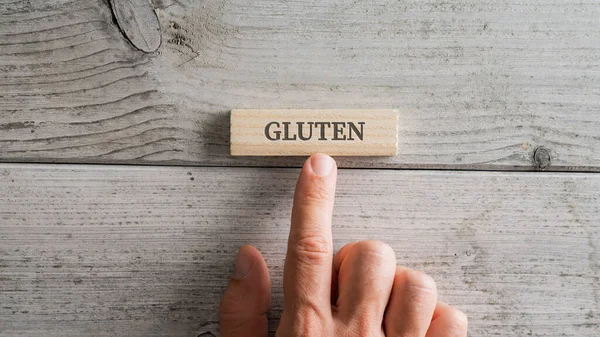 Male Hand Placing Wooden Peg Gluten Sign White Textured Wooden — Stock Photo, Image