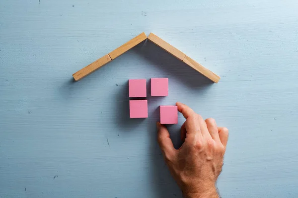 Férfi Kéz Épület Egy Ház Rózsaszín Blokkok Felett Kék Háttér — Stock Fotó