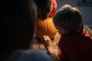 Aile cadılar bayramı balkabağı oymaya hazırlanıyor..