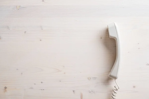 Простой Белый Стационарный Телефон Расположенный Обычном Деревянном Фоне Большим Количеством — стоковое фото