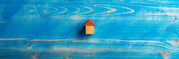 用木块做的房子 放在纹理蓝色的木制背景上的宽视图图像 有足够的复制空间 — 图库照片