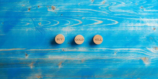 Trzy Drewniane Kółka Napisem Kup Sprzedaj Złoty Umieszczone Niebieskim Drewnianym — Zdjęcie stockowe