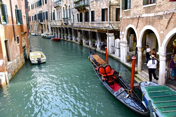 Gondolier et sa gondole colorée sur le canal vénitien — Photo