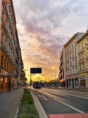 Wroclaw, Polonya - 25 Eylül 2020: Tramvayla caddenin üzerinde güzel bulutlu gün batımı