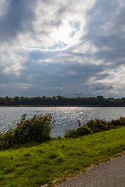 Büyük göl üzerinde bulutlu güneşli bir gün Parlayan suyla