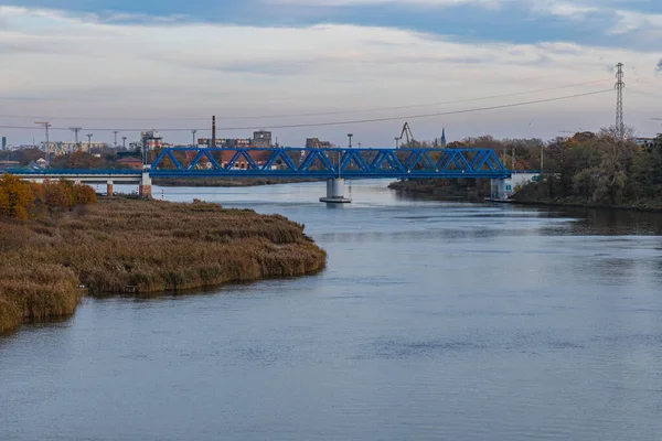 Wroclaw, Polonya - 15 Kasım 2020: Bulutlu bir günde Odra Nehri üzerindeki mavi uzun demiryolu köprüsü