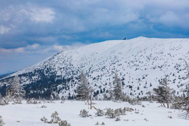 Bulutlu bir sabahta dağların ve tepelerin karlı manzarası