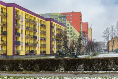 Zawiercie, Polonya - Nisan 2021: Karlı bir günde apartman bloklarının renkli cephesi