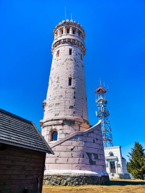 Baykuş Dağları, Polonya - Nisan 2021: Büyük Baykuş dağının zirvesinde eski izleme kulesi tabelaları ve tahta dev baykuşlarla dolu küçük bir meydan