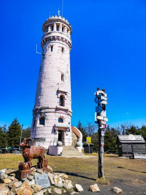 Baykuş Dağları, Polonya - Nisan 2021: Büyük Baykuş dağının zirvesinde eski izleme kulesi tabelaları ve tahta dev baykuşlarla dolu küçük bir meydan