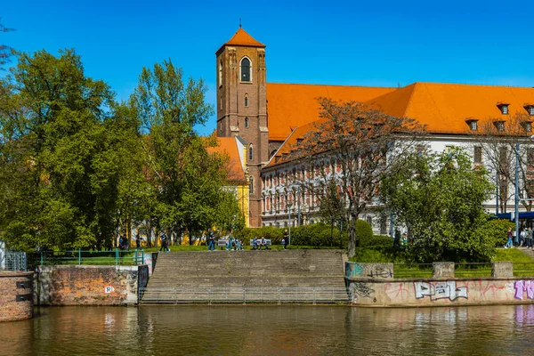 Wroclaw, Polonya - Nisan 2021: Piasek adasında St. Katolik Kilisesi ile küçük yeşil meydan Kutsal Bakire Meryem arka planda
