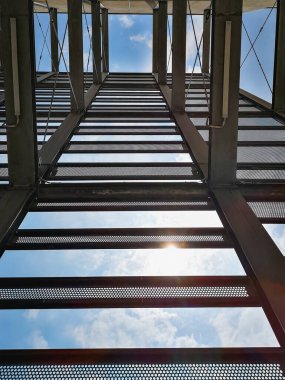 Güneşli bir günde apartmanın yanındaki metal inşaatına bakıyorum.