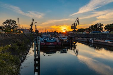 Wroclaw, Polonya - Haziran 2021: Eski şehir limanının kalıntıları ve eski binaların üzerinde güzel renkli gün batımı