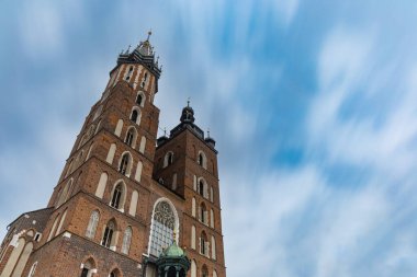 Cracow, Poland - July 3 2021: Looking up to towers of St. Mary's Church at cloudy day