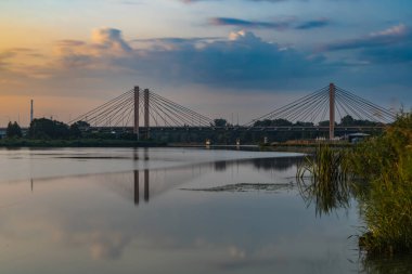 Wroclaw, Poland - July 25 2021: Odra river with big millennium bridge over it reflecting in water at cloudy morning after sunrise