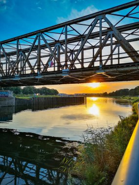 Wroclaw, Poland - July 27 2021: Beautiful cloudy sunset seen over Odra river next to walking path