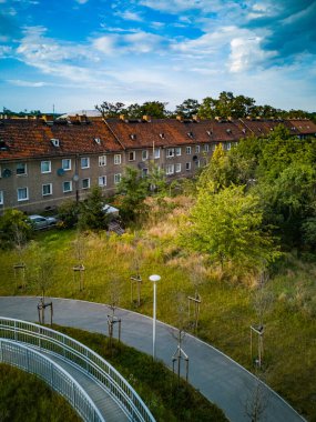 Wroclaw, Polonya - Ağustos 2021: Güneşli bir günde tren rayları ve karayolu üzerindeki uzun beton köprü ve çalılara bakın