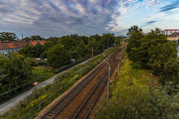 Wroclaw, Poland - August 2021: View from long concrete footbridge over train rails with at sunny cloudy day